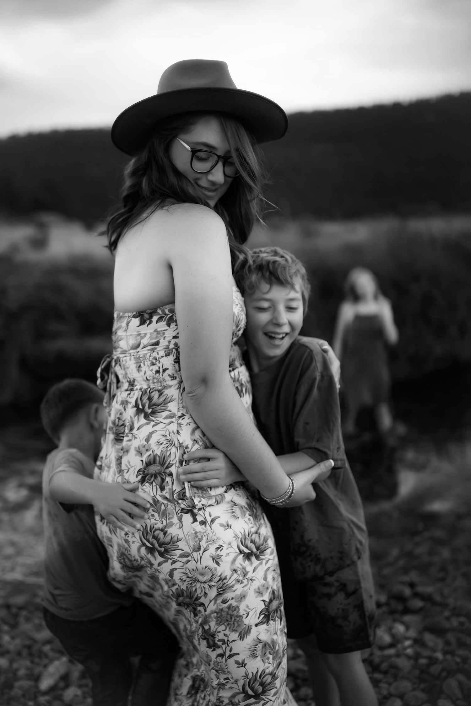 A series of black and white photos showing tender moments between two people in a floral dress and dark clothing.