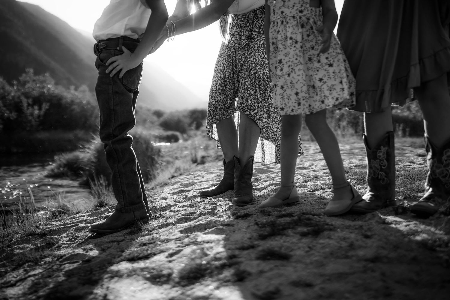 Close-up view of feet walking on a rocky outdoor path in dramatic black and white.