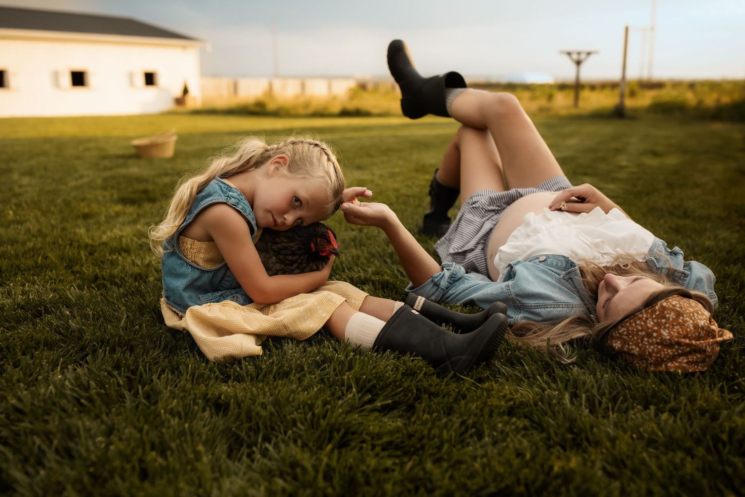 Relaxed summer photoshoot in a grassy field with vintage farmhouse backdrop.