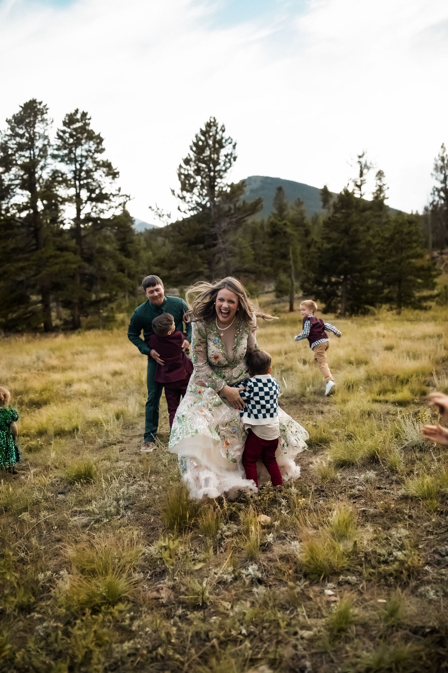 A playful family moment captured in a golden mountain meadow at sunset.