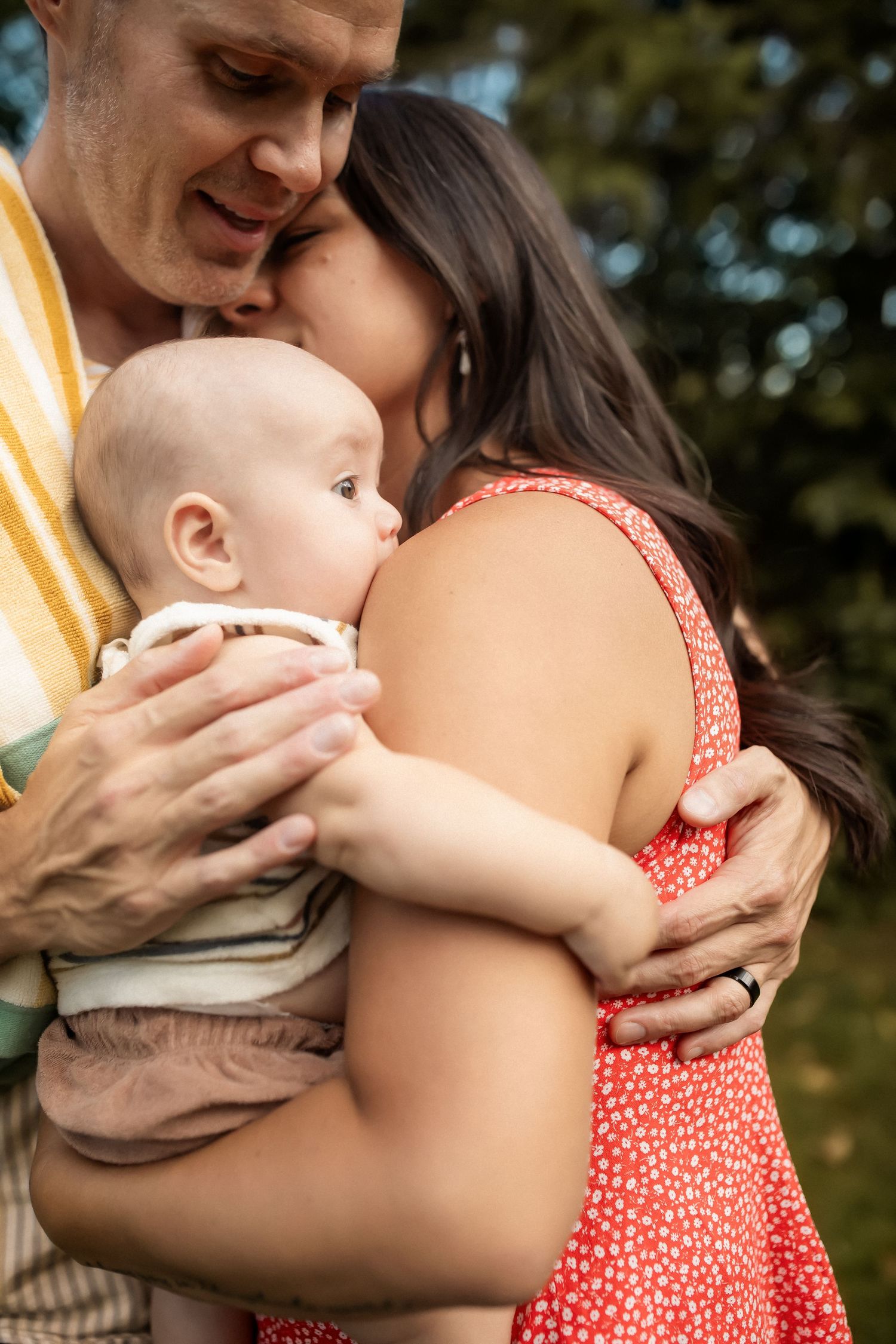 Tender family moment captured outdoors showing intimate bonding and affection.