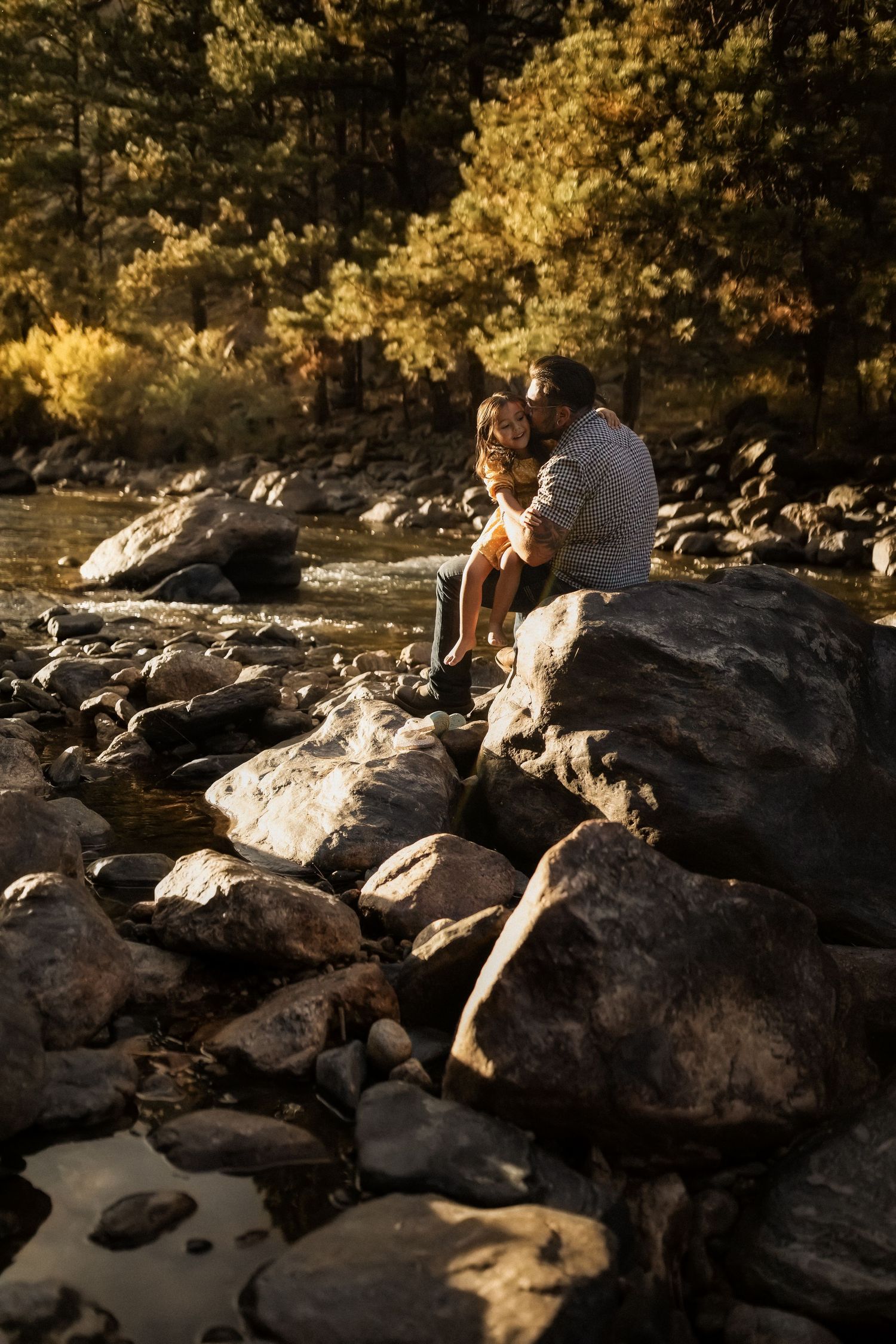 People sitting on large rocks during golden hour in natural setting.