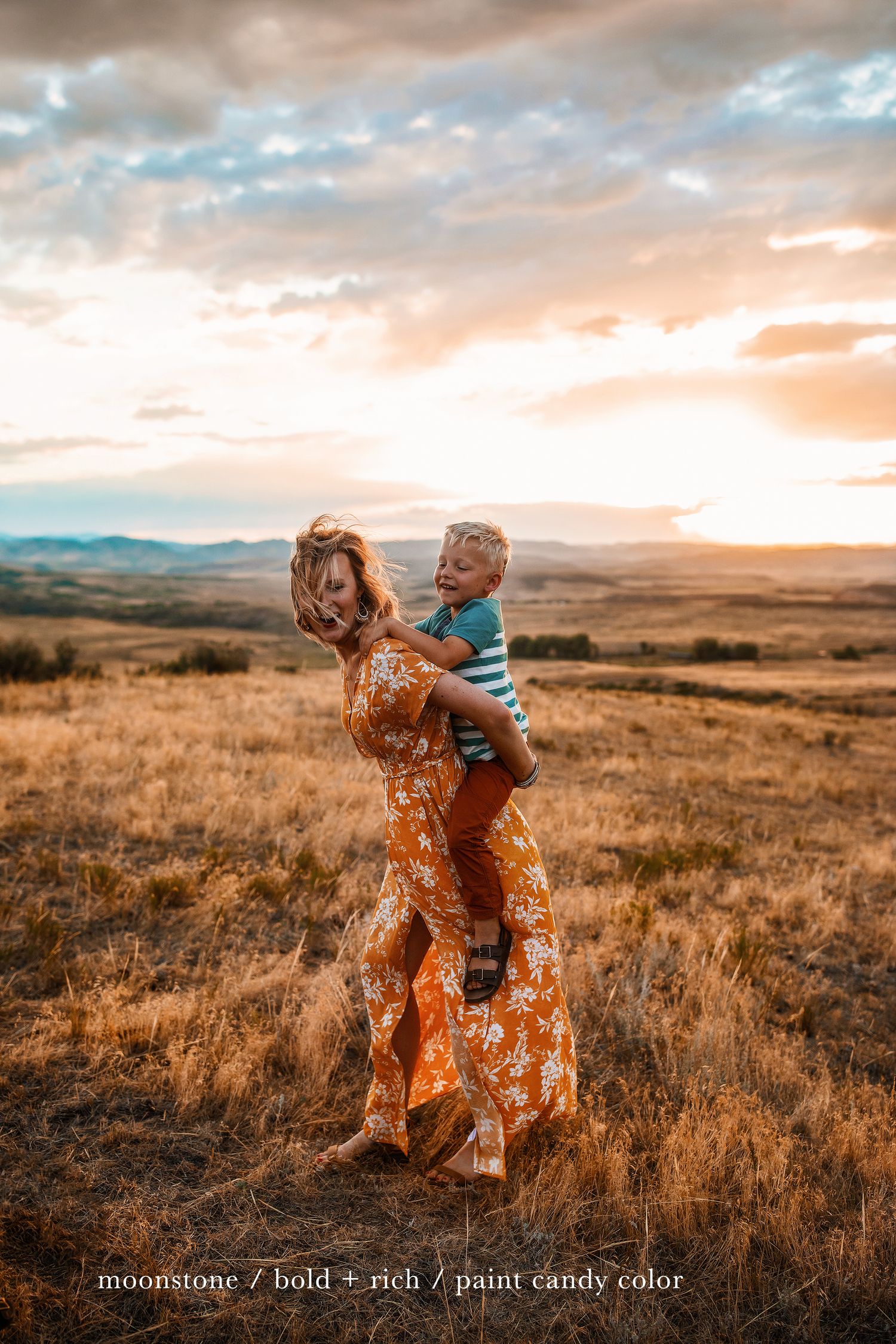 Candid family moment in rustic field landscape during magical sunset hour.