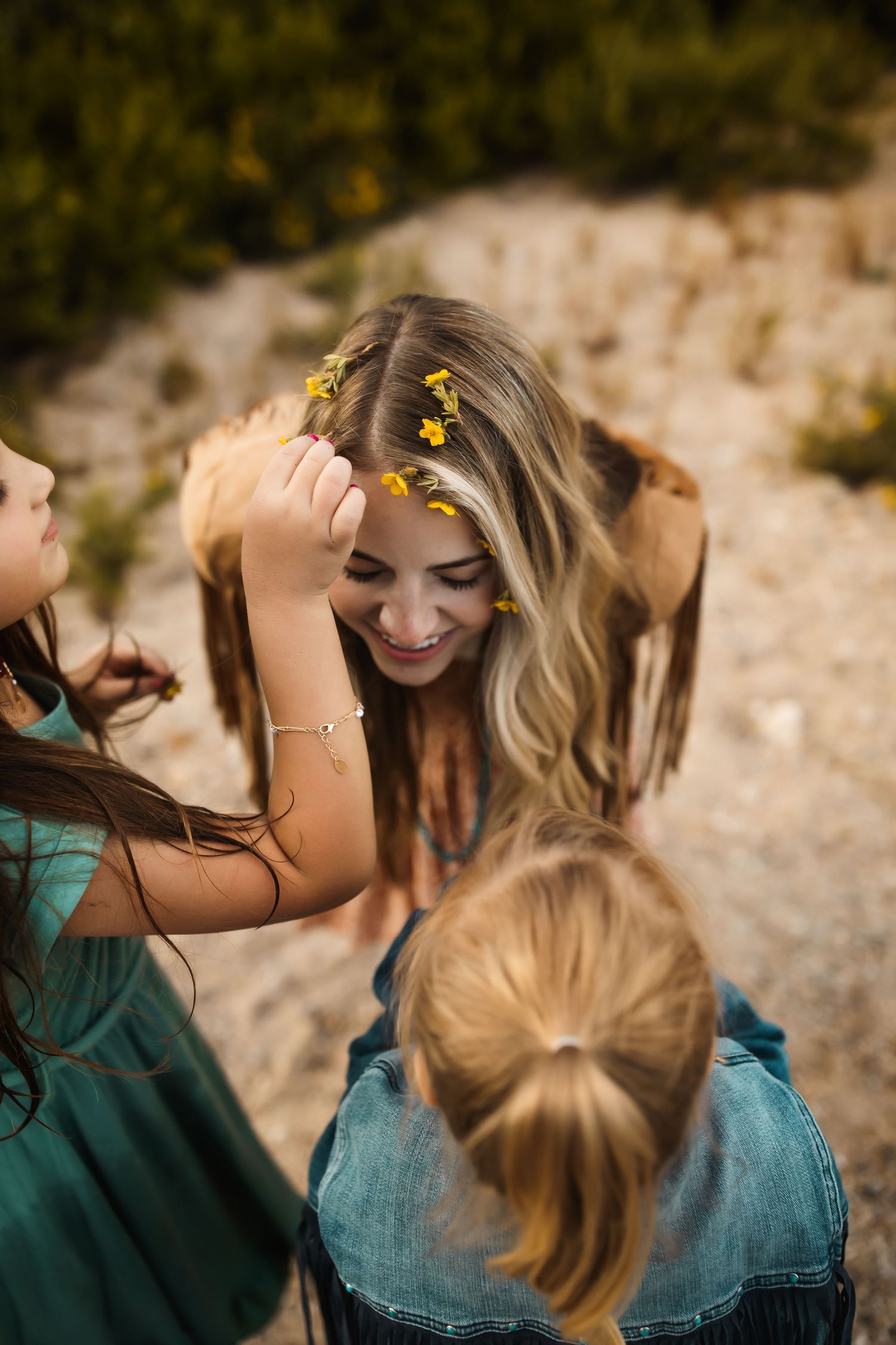 Friends with yellow flowers in their hair sharing joyful moments outdoors.