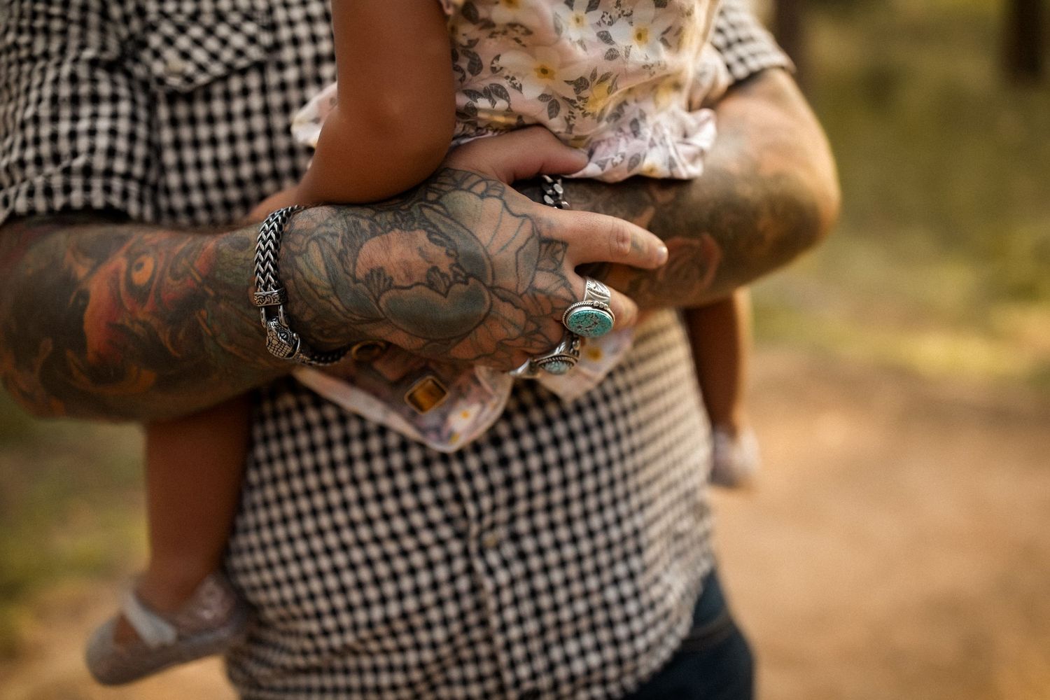 Close-up shots showing tattooed arms and casual clothing in warm outdoor lighting.