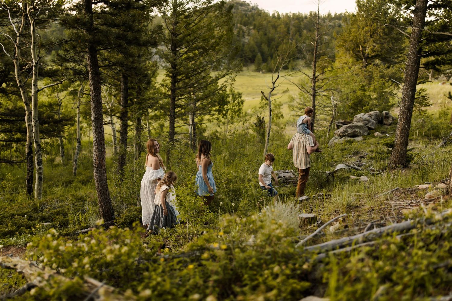 Group walking through wooded mountain trail during autumn.