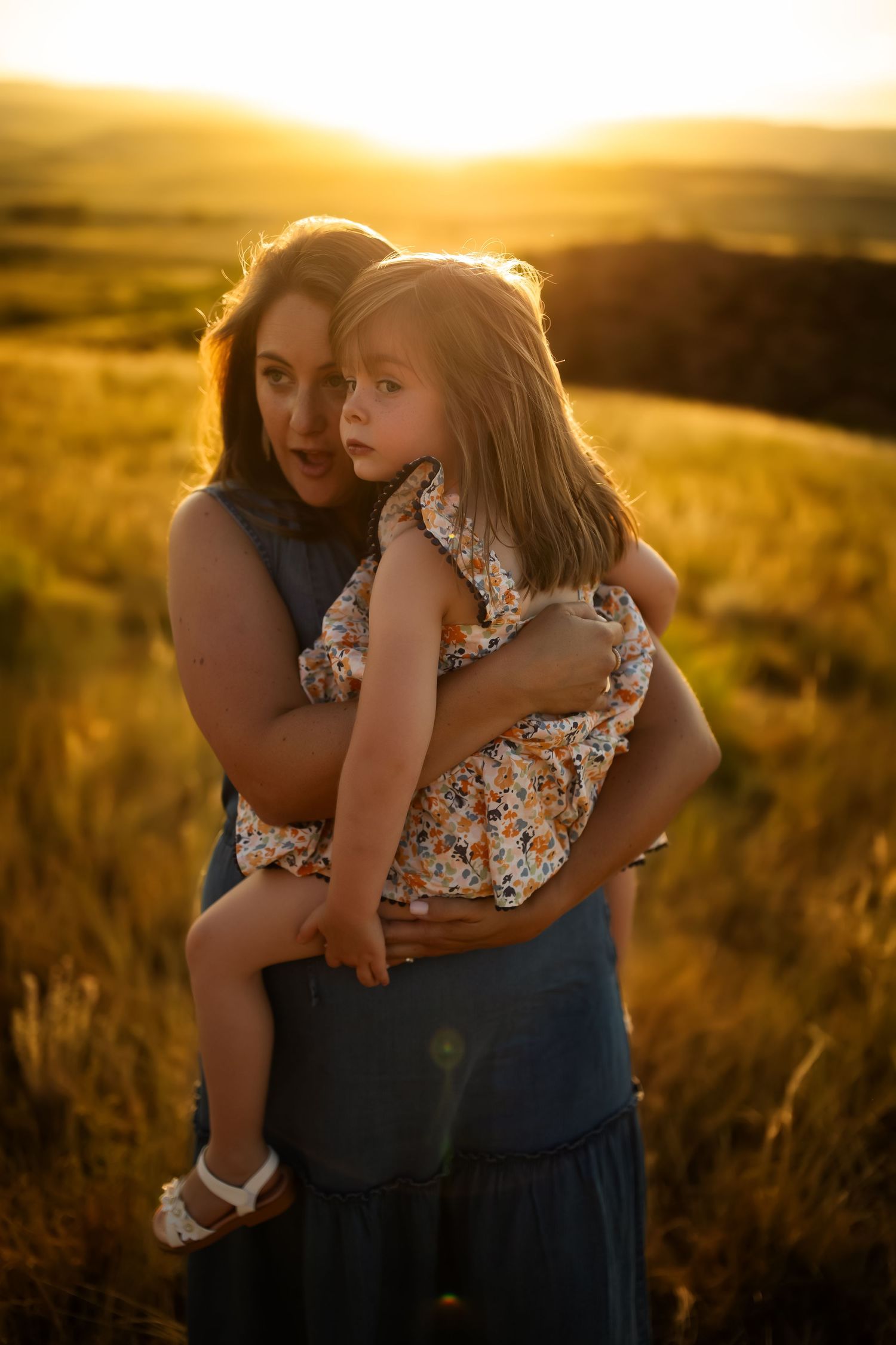 A tender moment between parent and child in a sunlit meadow at golden hour.