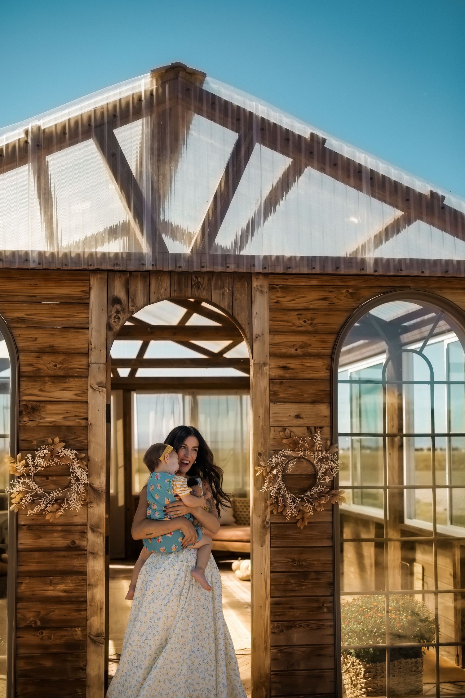 Rustic wooden archway with decorative wreaths framing tender family moment.