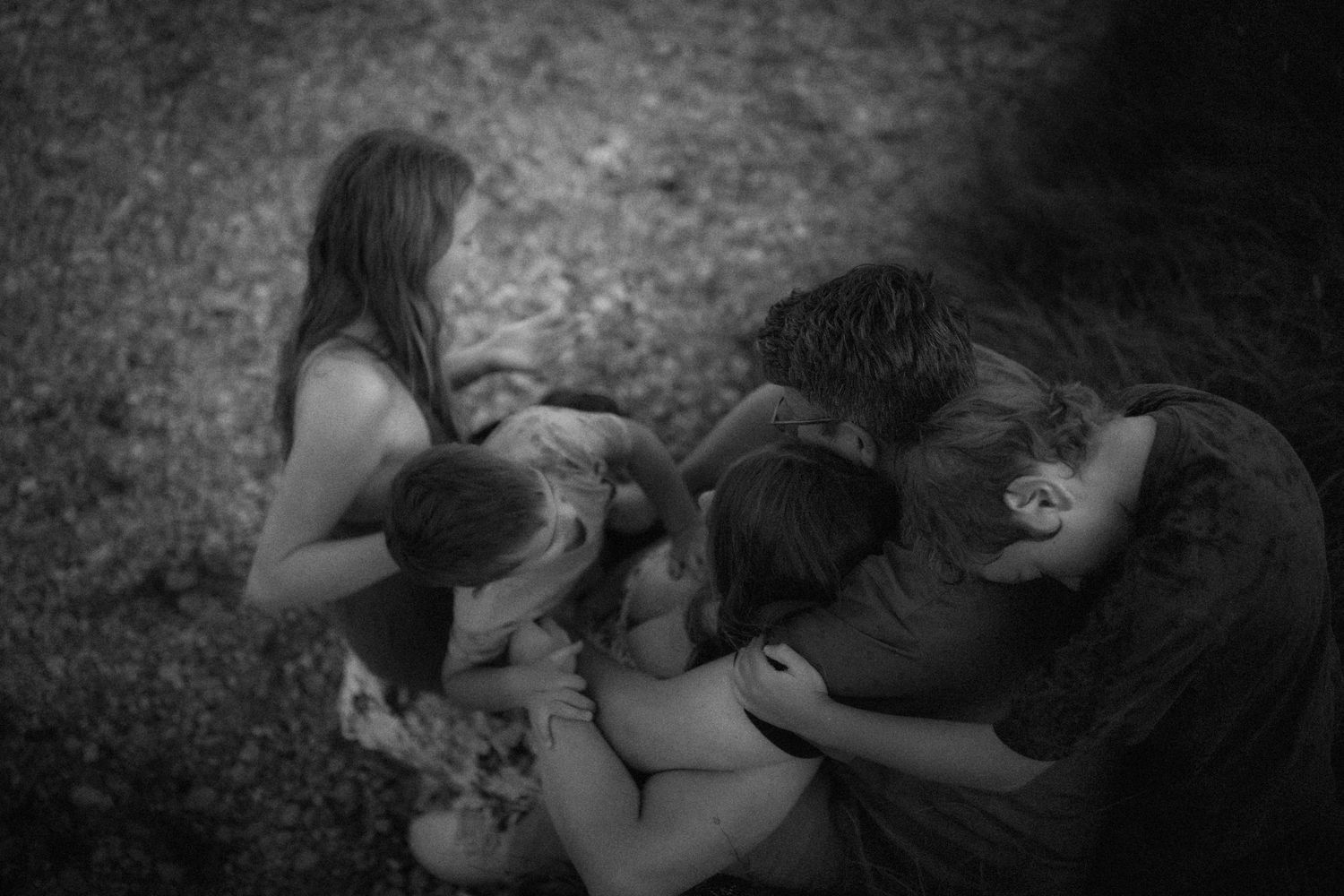 Intimate black and white photos of people lying together on the ground.