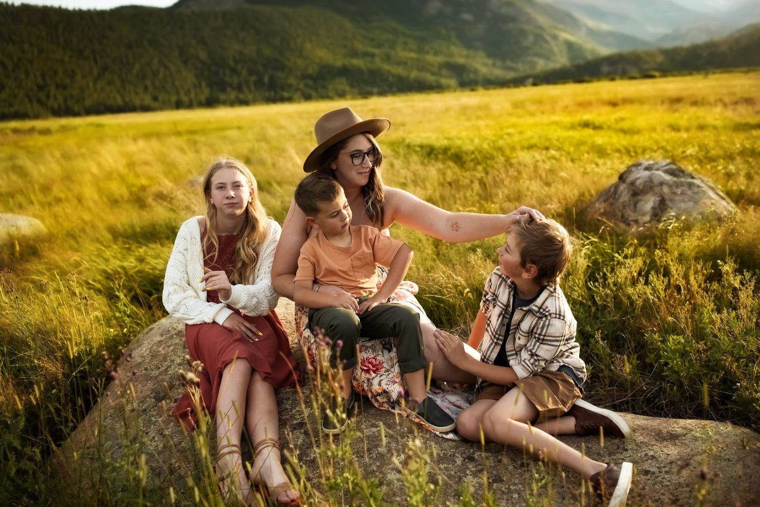 Group enjoying a picturesque mountain view while sitting in a wildflower meadow at golden hour.