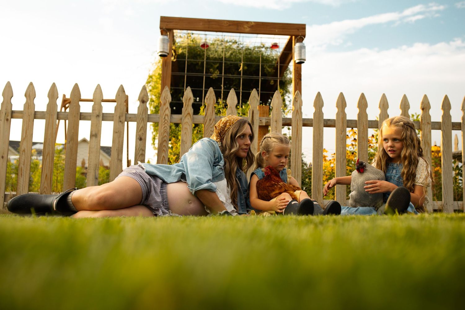 Rural backyard scene with white picket fence and golden evening light.