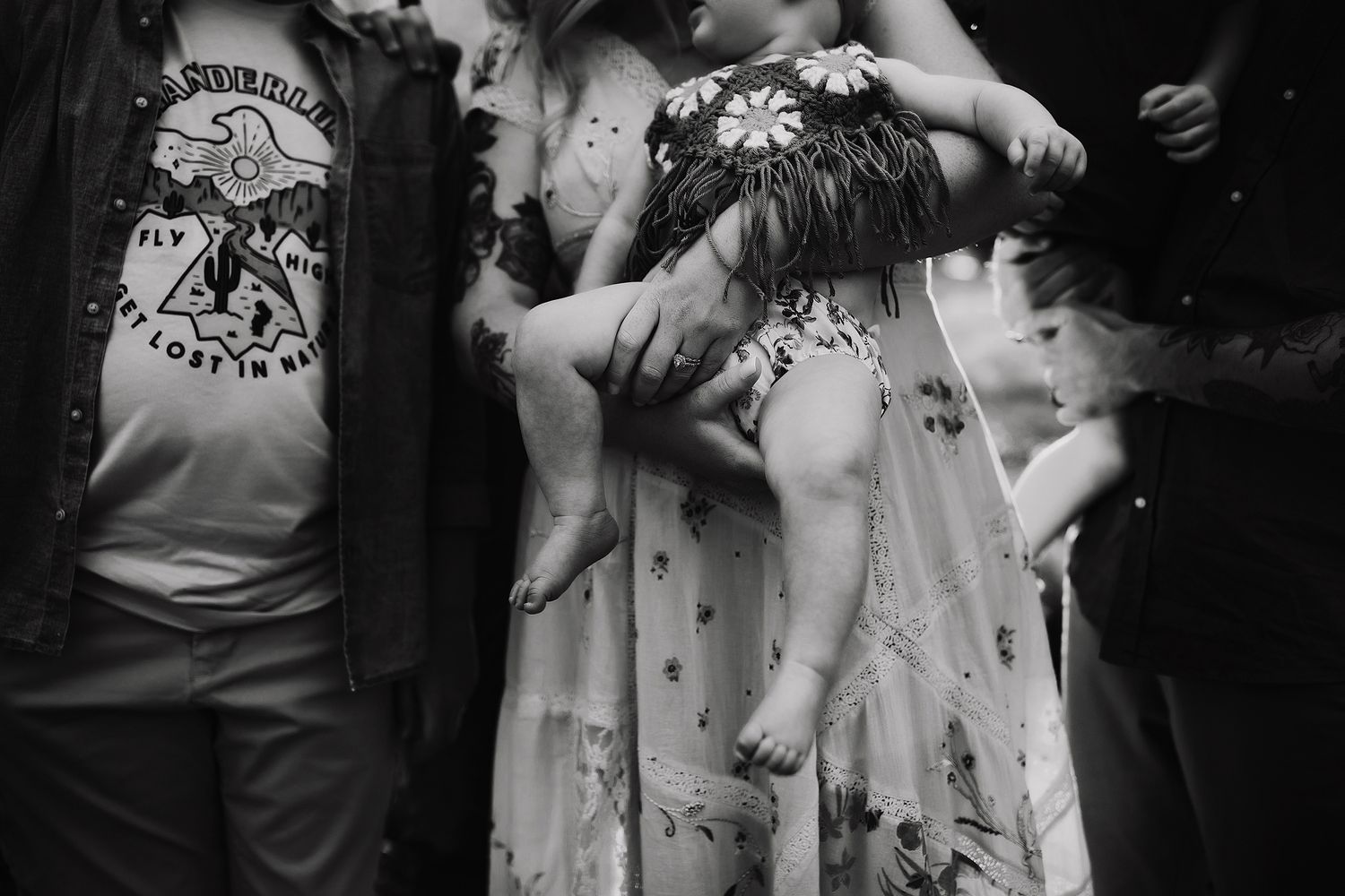 Black and white photo of dancers in floral dresses moving together at a lively dance gathering.
