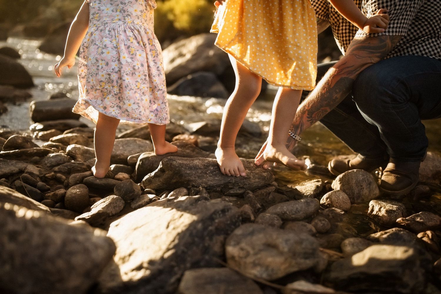 Bare feet walking on dark rocky terrain in natural sunlight.