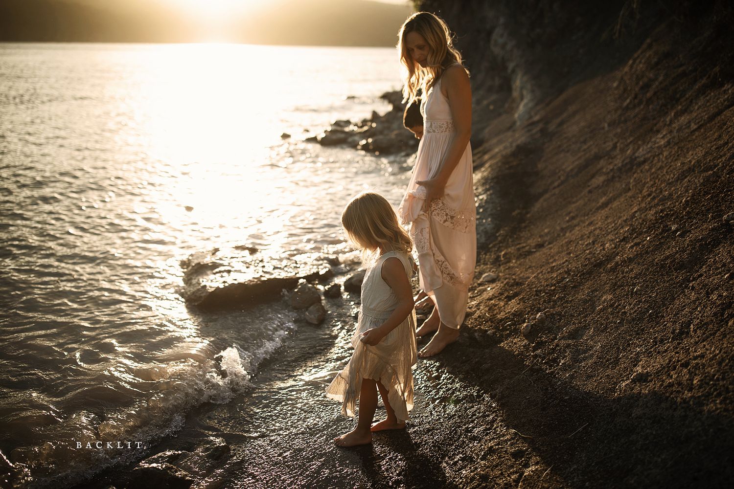 Artistic silhouette photography of people by the water's edge at sunset.