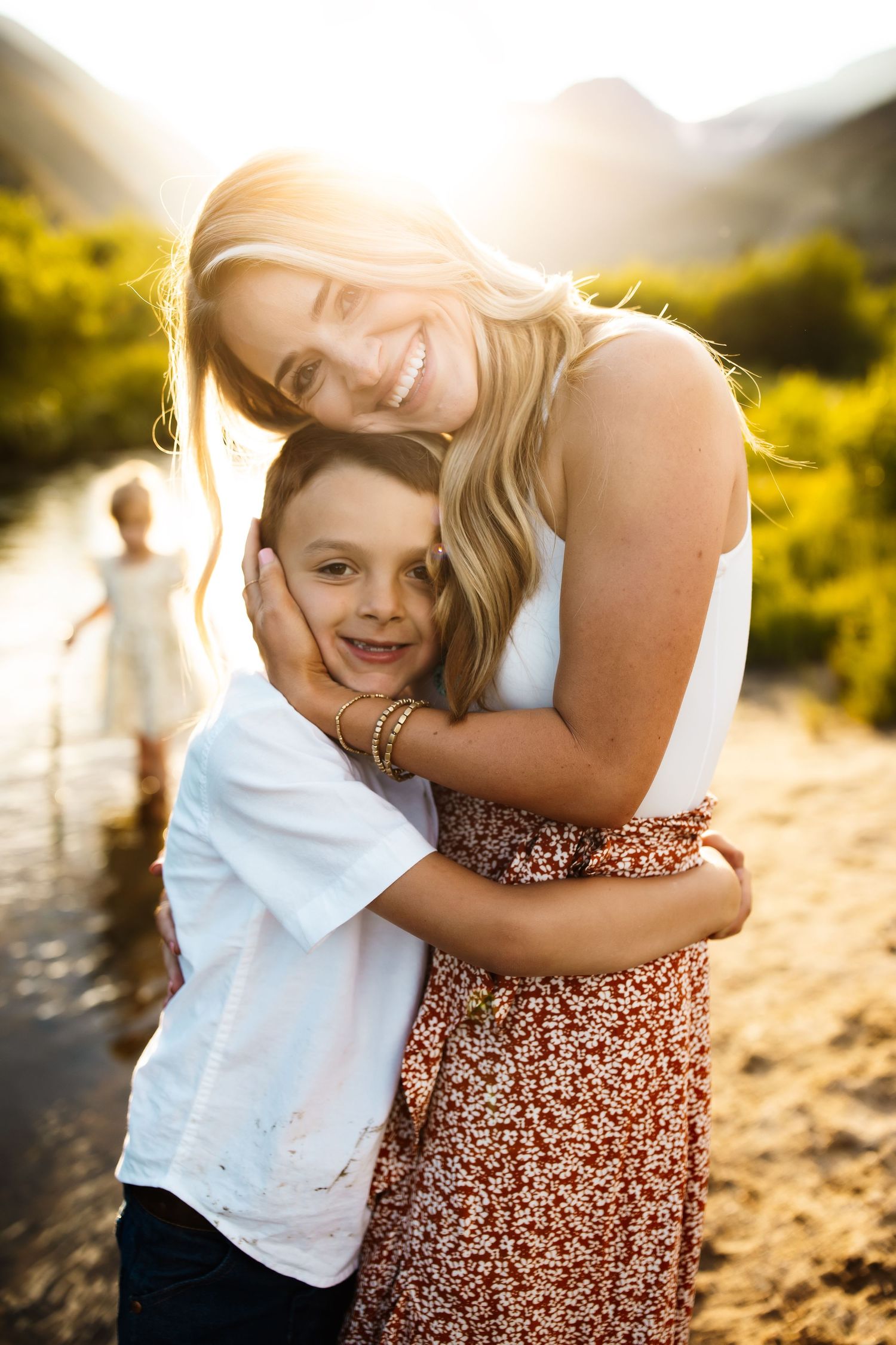 Sweet embrace between parent and child in golden sunlit field.