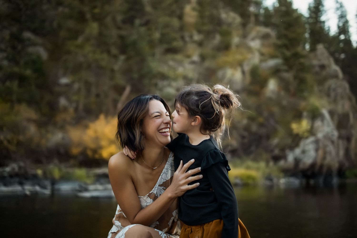 A romantic outdoor photoshoot at sunset with mountains and trees in the background.