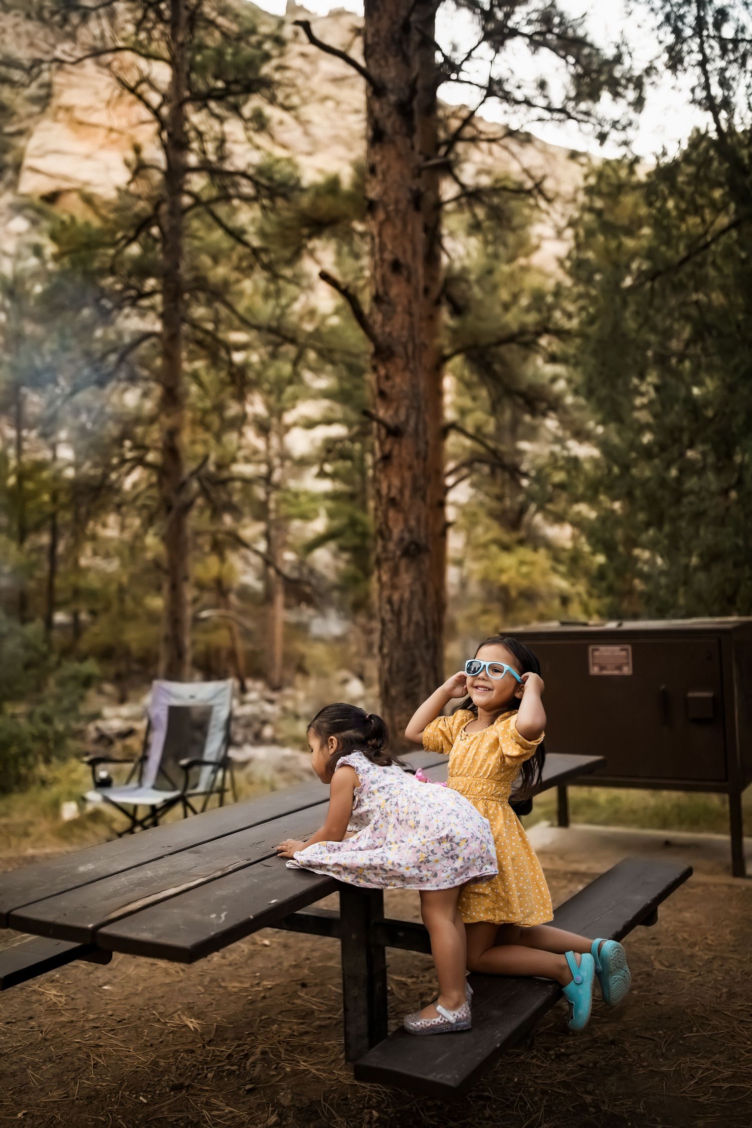 A series of candid shots showing someone in a floral dress and blue socks lounging playfully on a wooden picnic bench.