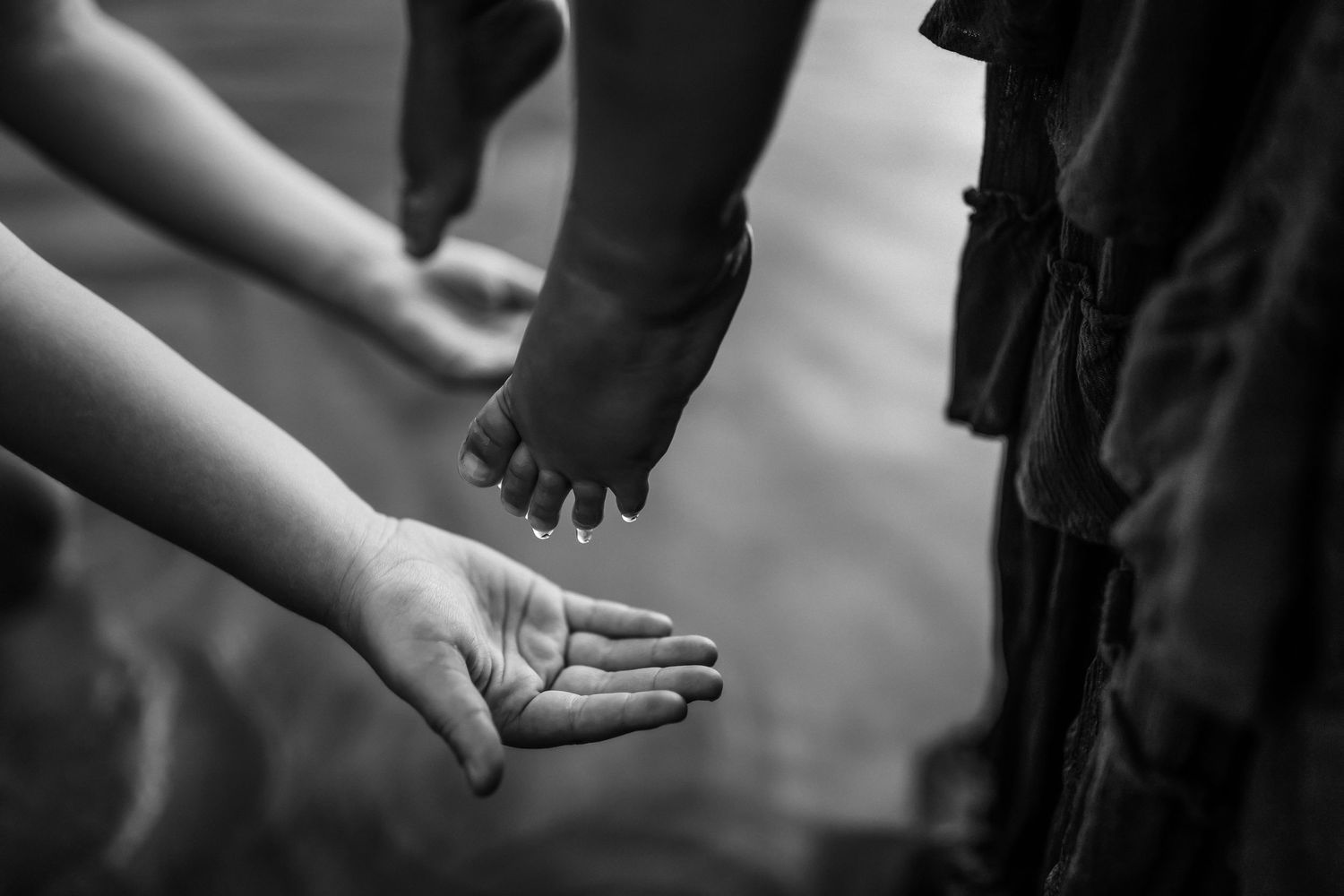 A series of black and white photos showing hands reaching out and connecting in various gestures of support.