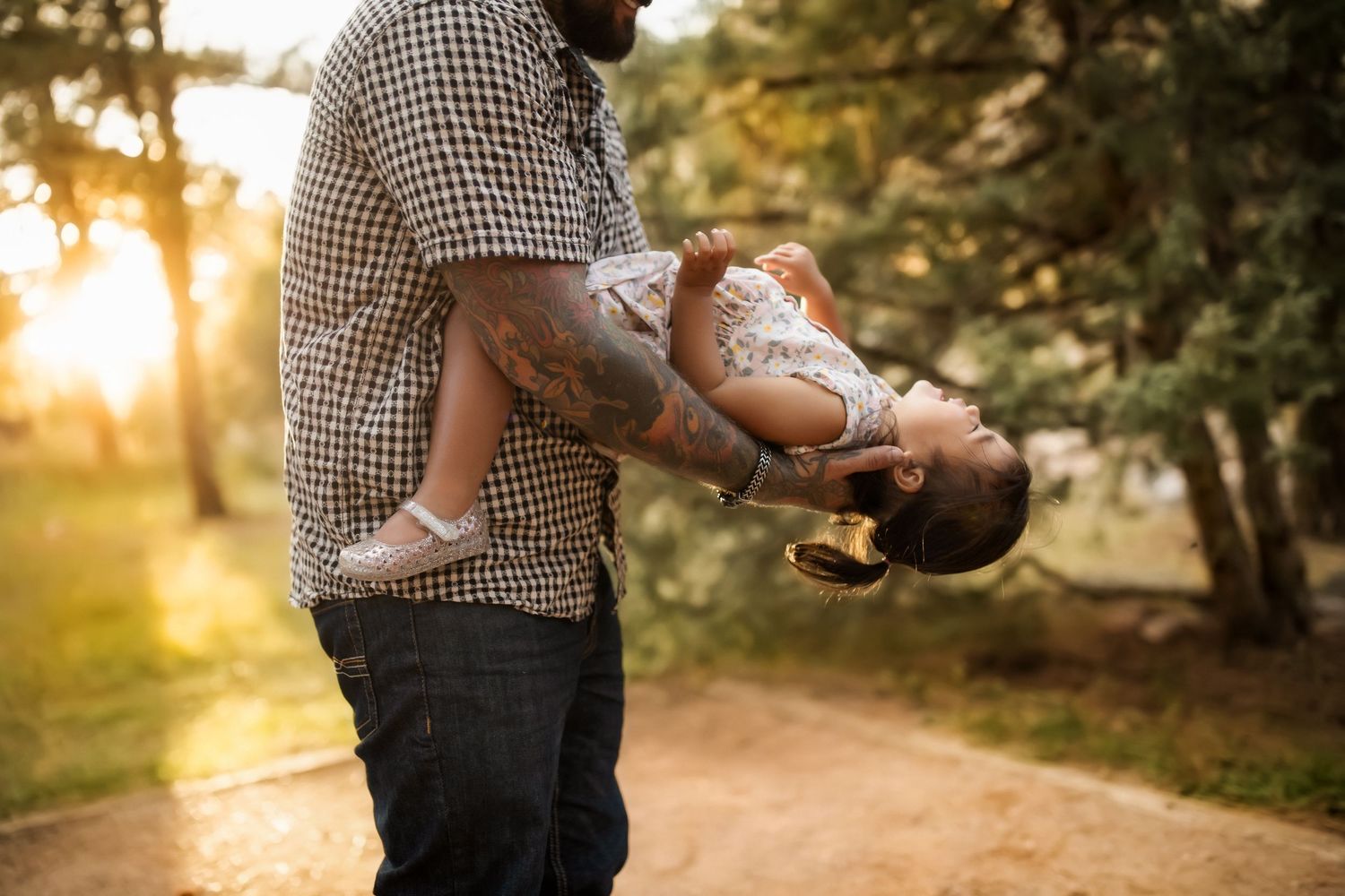 People sharing intimate moment in sunlit forest setting.