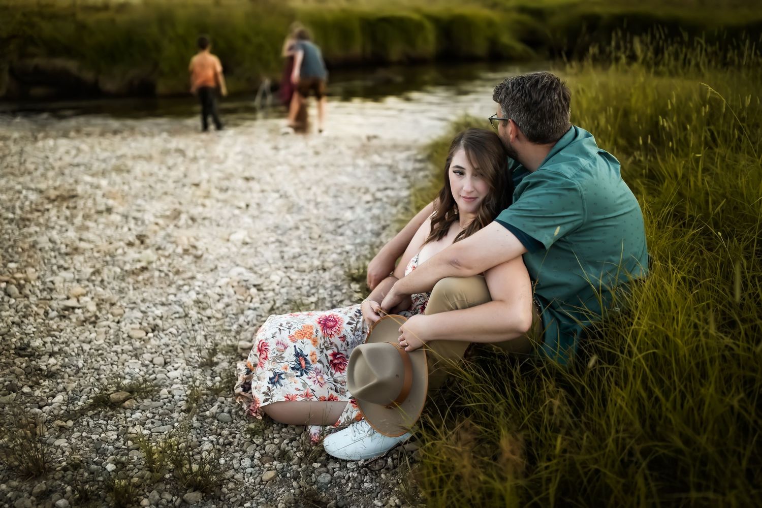 People sitting together on rocky ground during golden hour in a natural outdoor setting.