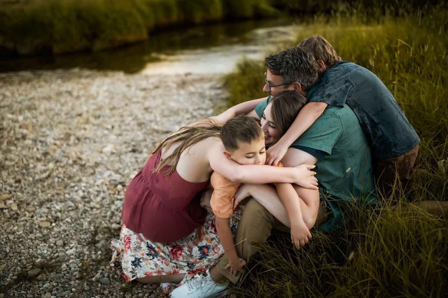 Intimate family portraits taken in tall grass during golden hour.
