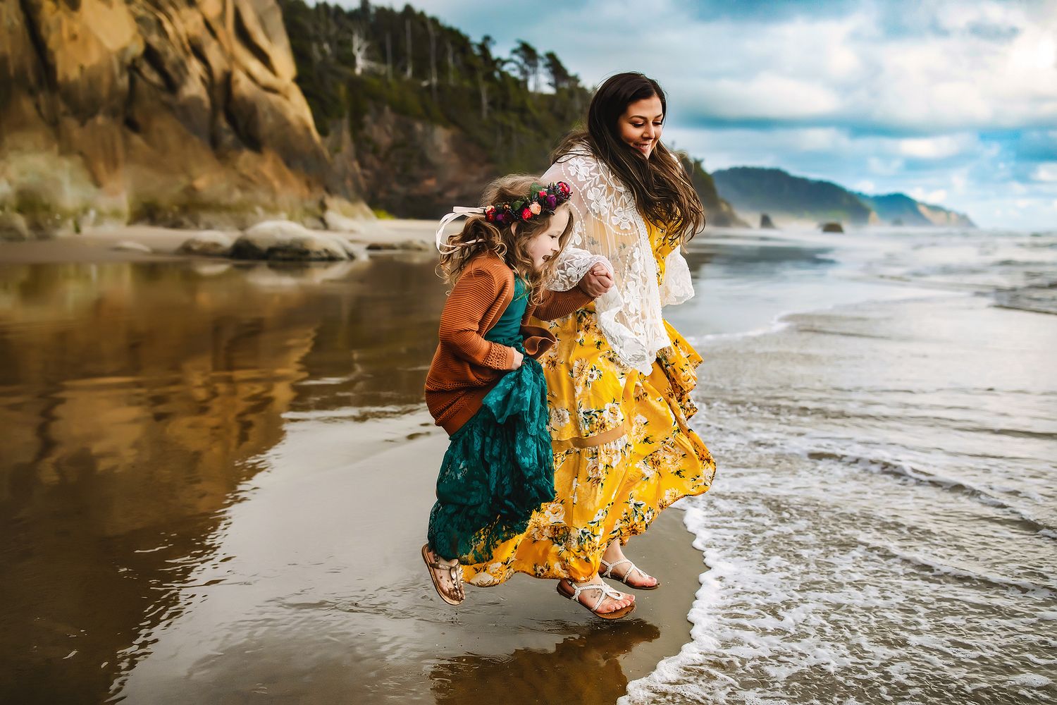 Emerald green dress flows gracefully as waves crash on a scenic beach during golden hour.