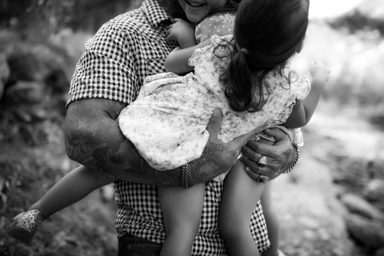 Black and white photo series showing hands holding and breaking apart a fresh loaf of rustic bread.