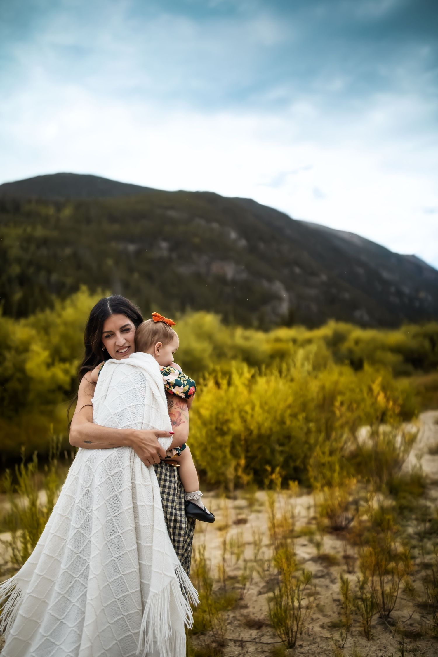 A touching moment shared with a white blanket against a mountainous autumn landscape.