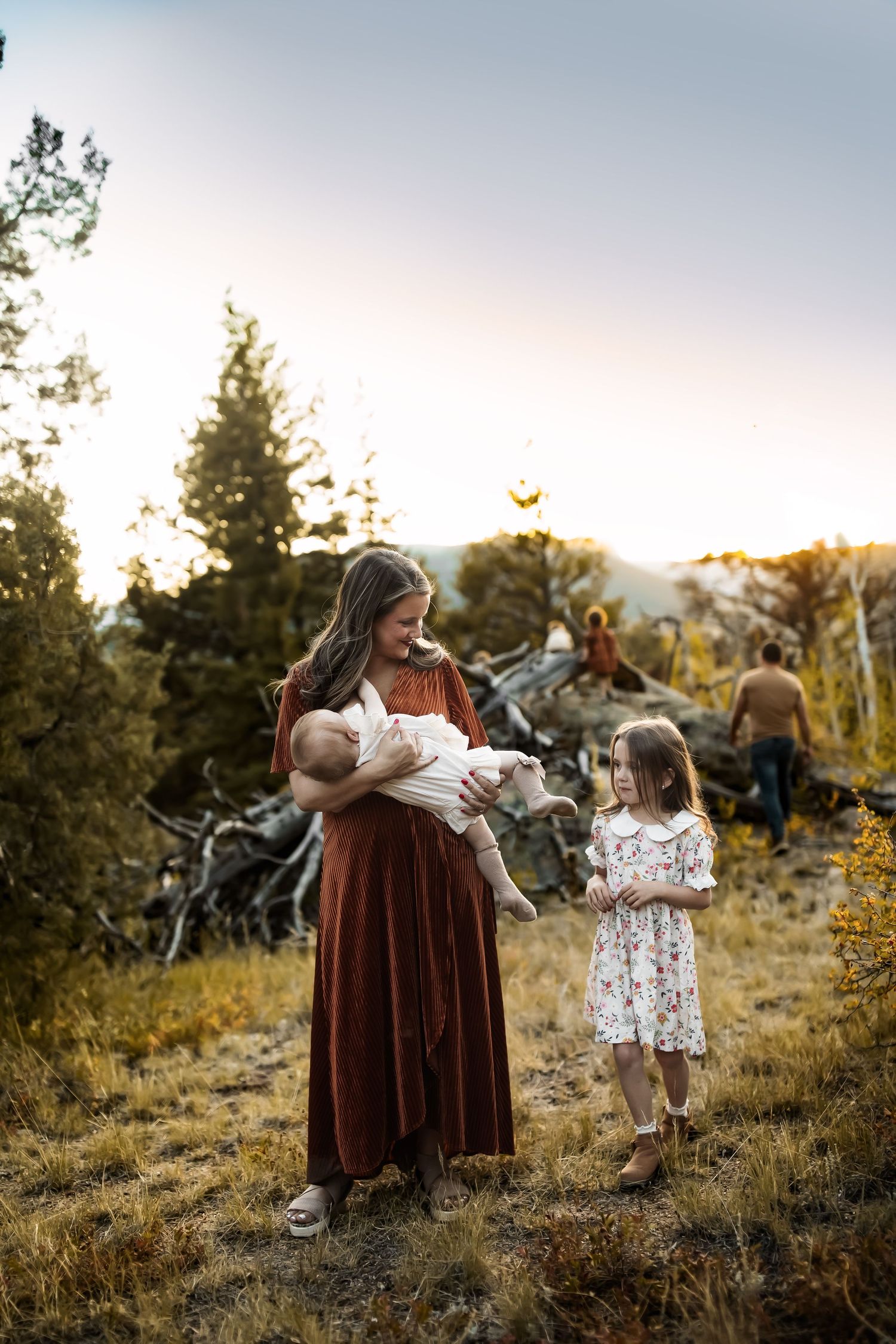 Family sharing tender moments together in a rustic outdoor setting at sunset.