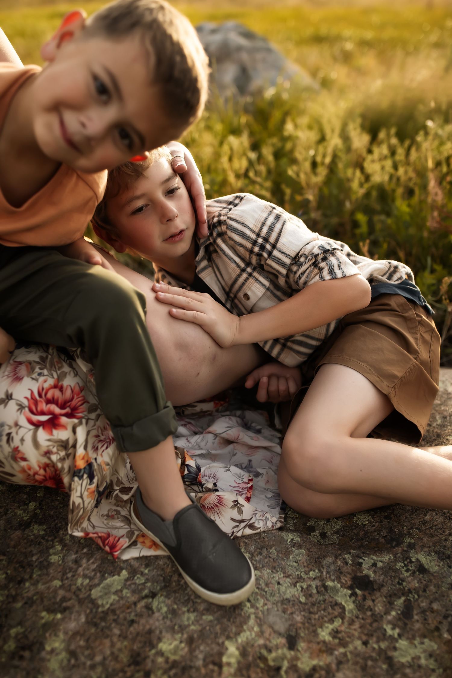 Two people lying in grass during golden hour sharing an intimate moment in a series of romantic outdoor photos.