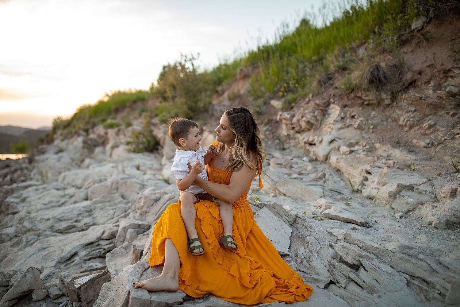 Family portrait session on rocky coastal terrain during sunset.