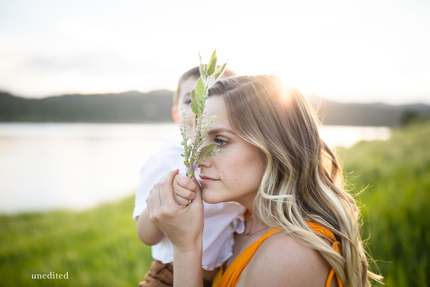 Ethereal sunlit portrait with delicate flowers in natural outdoor setting.