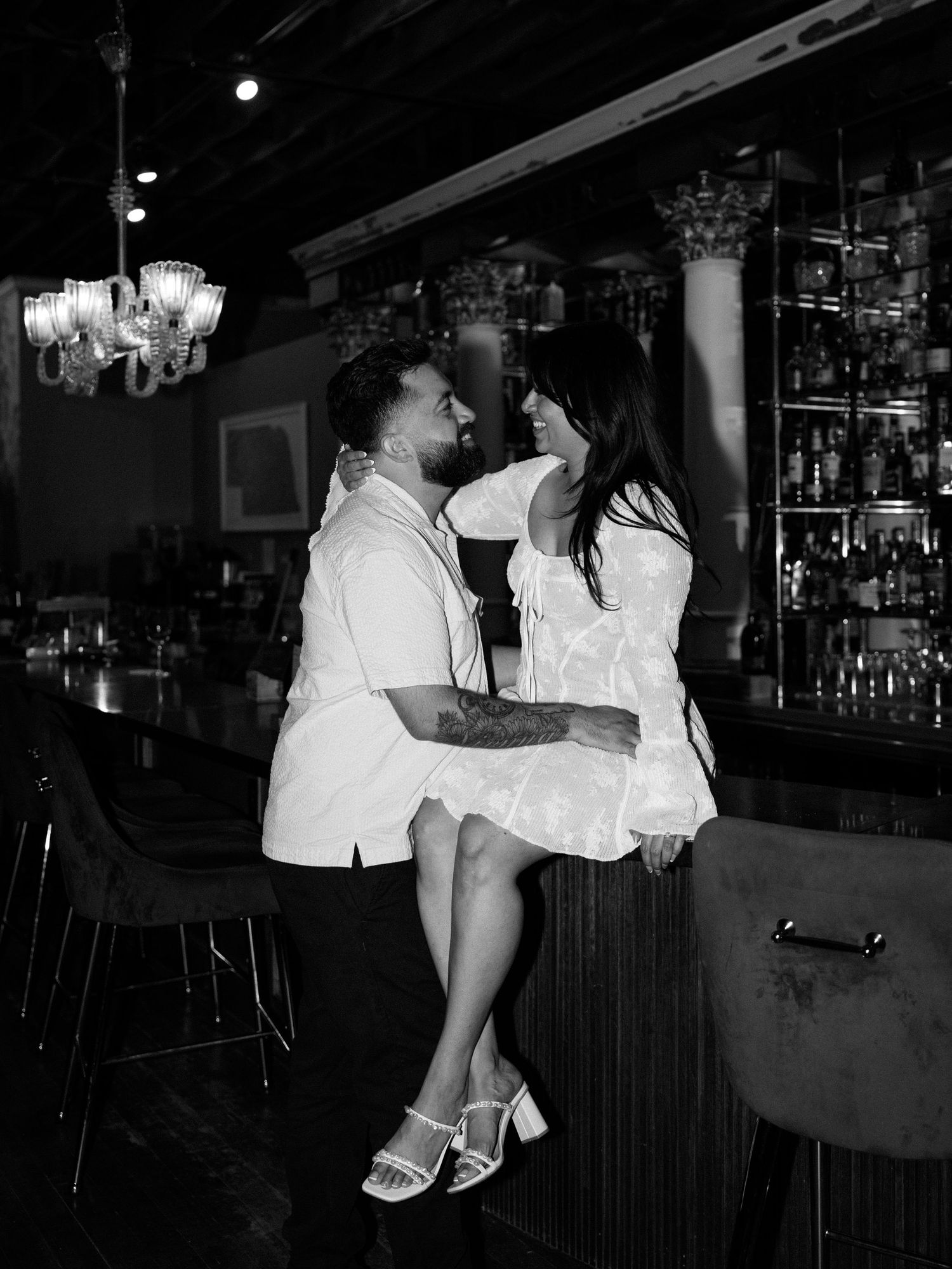People in white outfits dancing and having fun at a dimly lit bar.