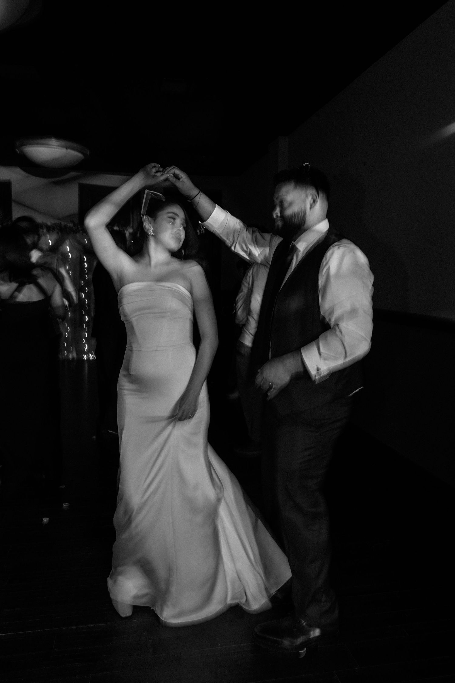 Black and white photo of a bride and groom sharing a romantic dance at their wedding reception.