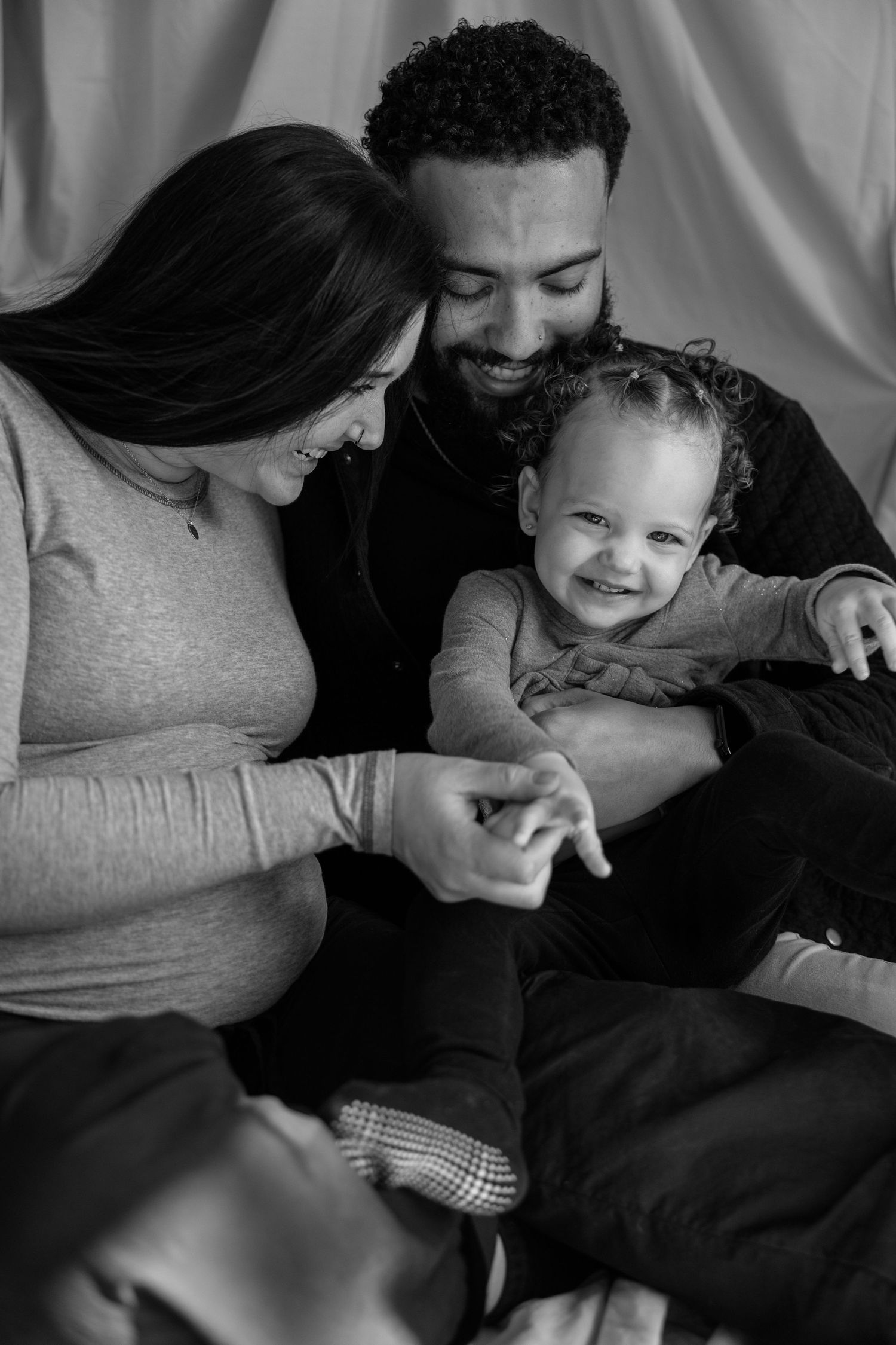 Close-up black and white portrait of family sharing a tender moment together.