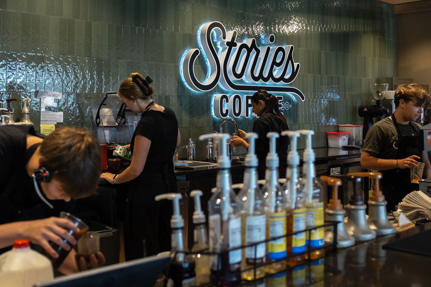 Interior of coffee shop with Stories Coffee Co signage and bar seating.