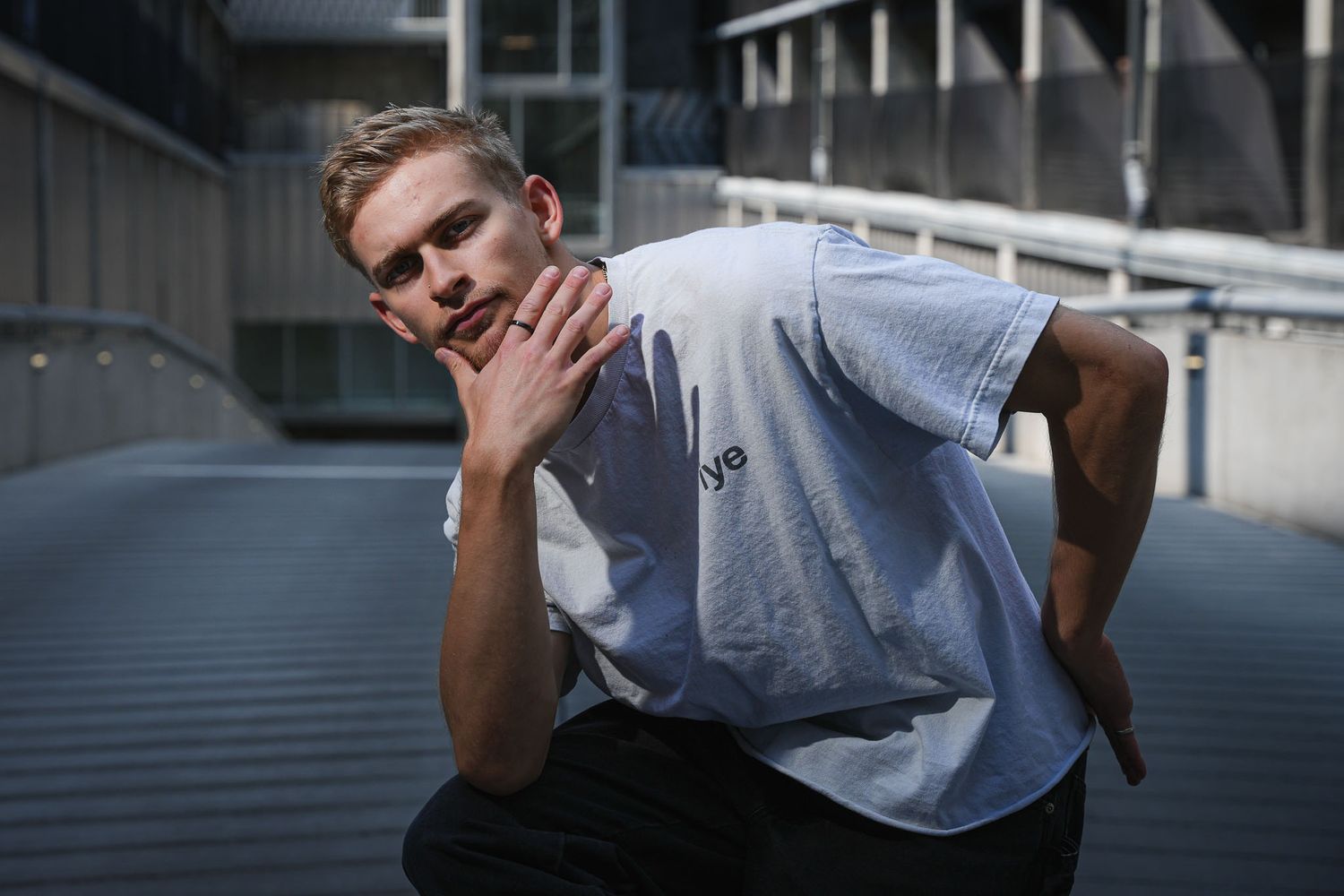 Candid portrait sequence captured against industrial building backdrop.
