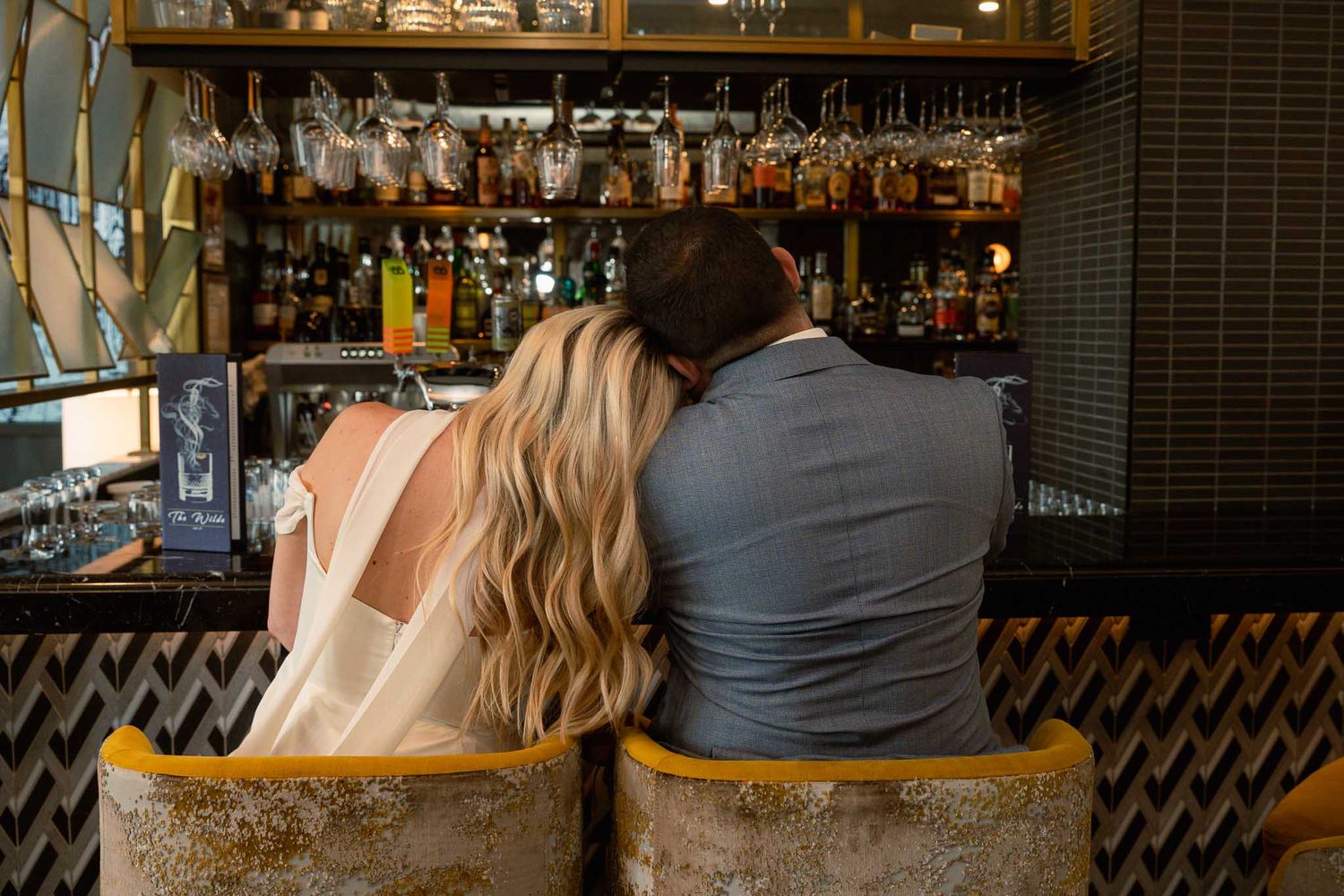 Wedding celebration candids at a bar with decorative lighting and rustic decor.