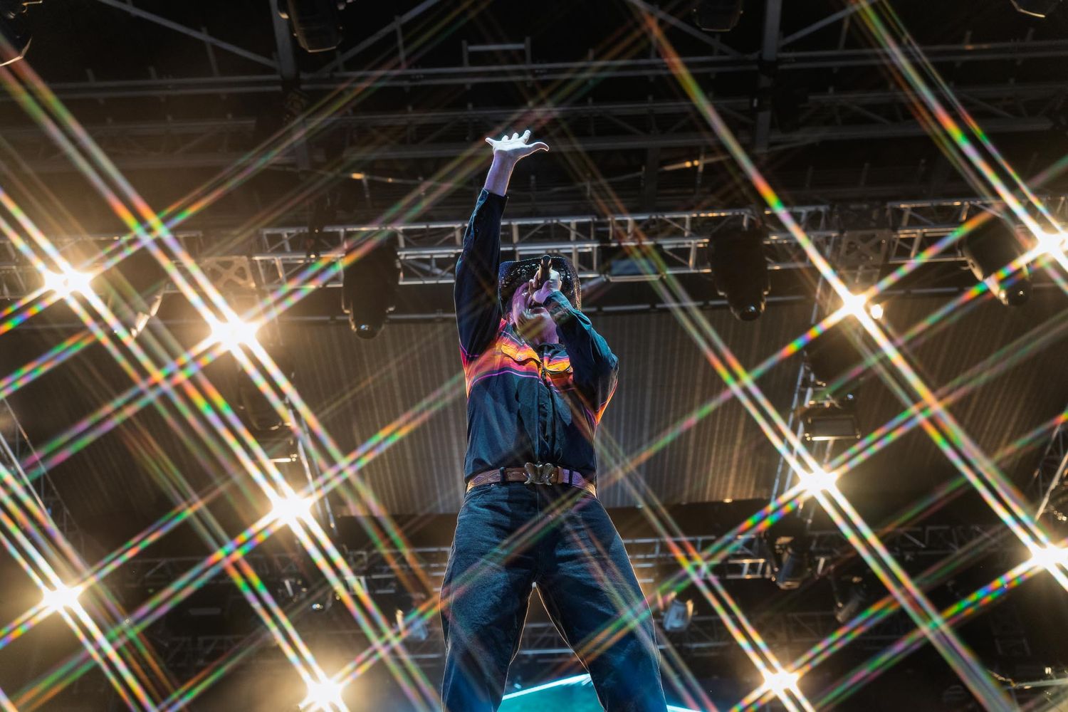 The Arkells on stage with dramatic crisscrossing light beams creating a dynamic concert atmosphere.
