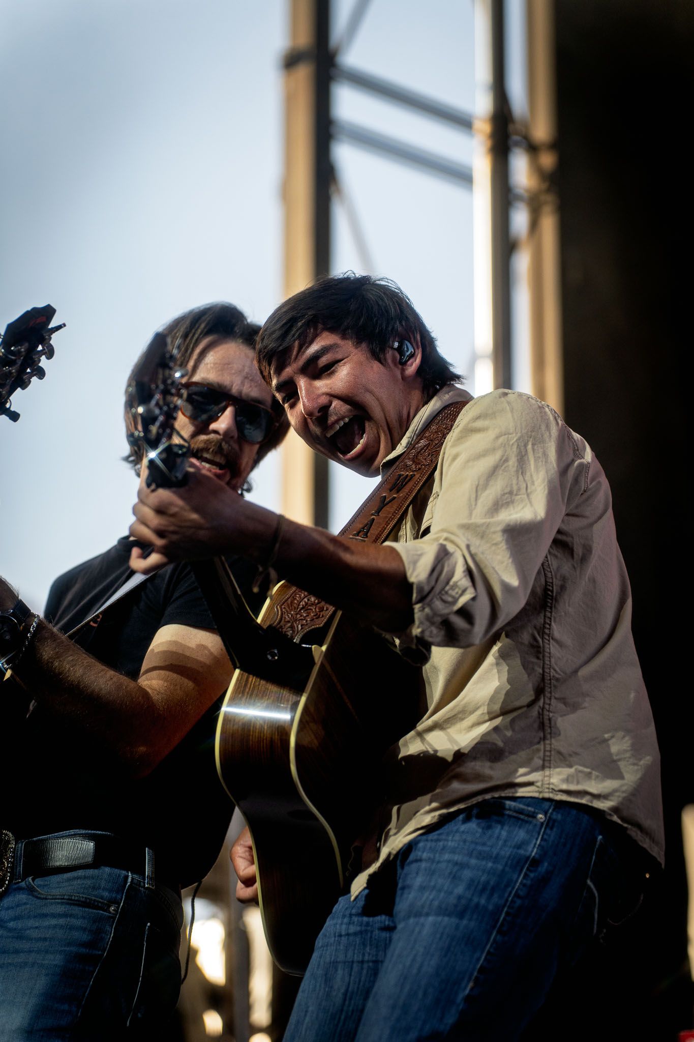 Musicians play acoustic instruments during daytime outdoor performance.