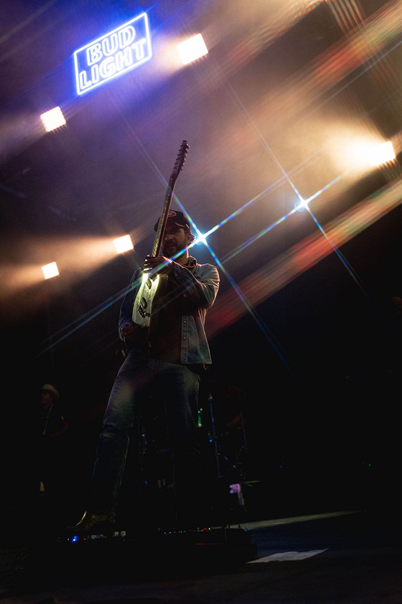 Silhouettes of performers on stage with dramatic blue lighting and fog effects.