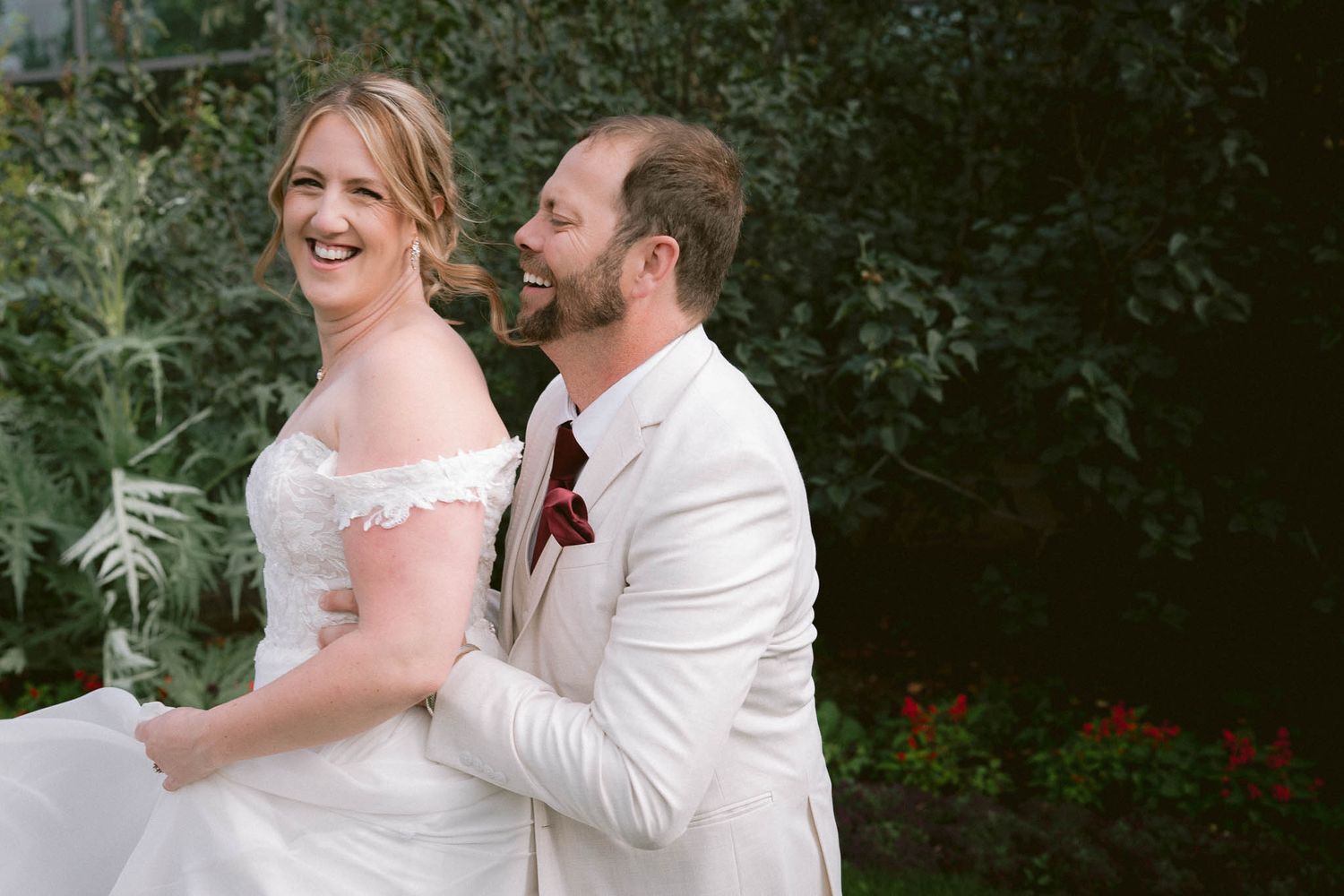 Couple shares tender moments in a garden setting with white attire.