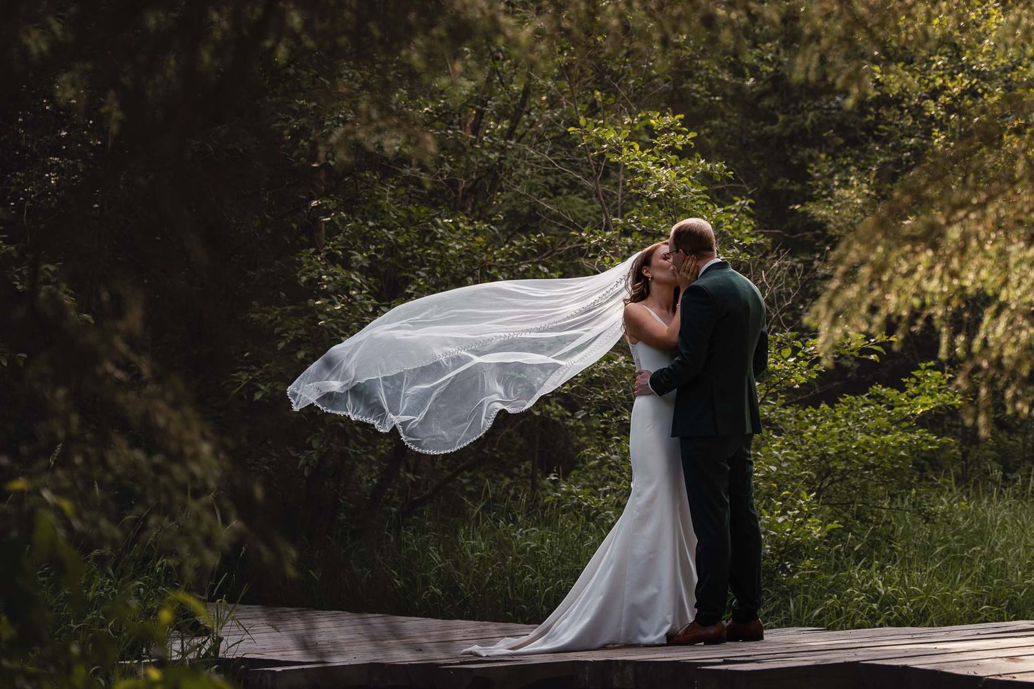 Couple shares intimate wedding moments in lush garden setting with flowing white dress.