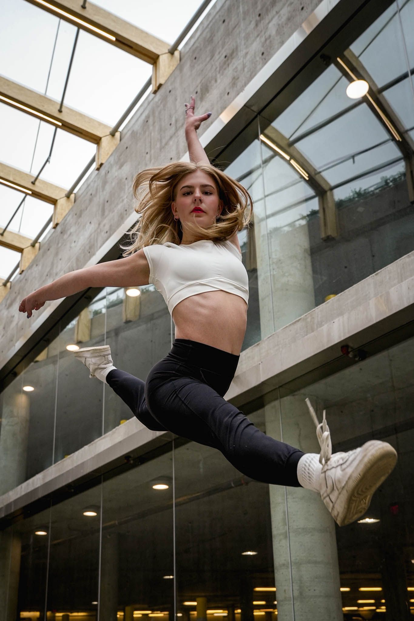 Modern dance performance with dramatic poses against an industrial backdrop with skylights.