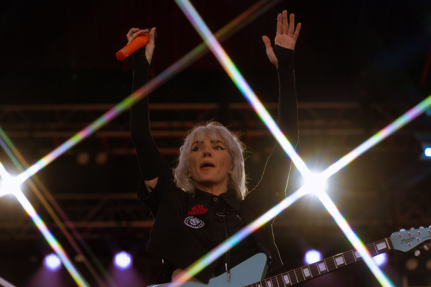Concert performer Lights singing passionately on stage with dramatic lighting and star burst effects.