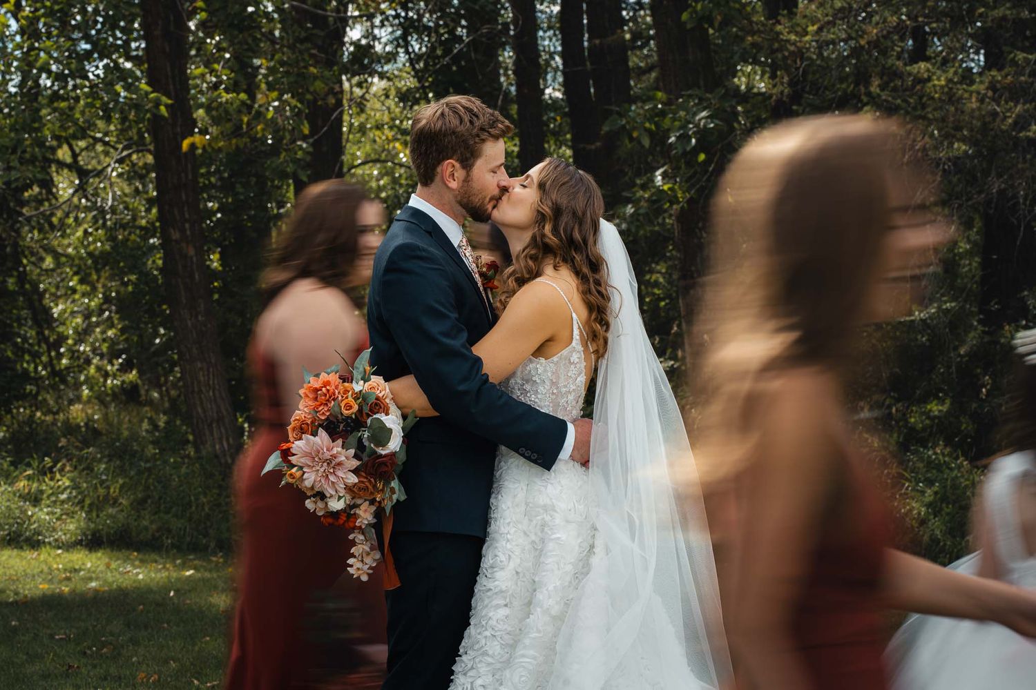 Wedding celebration in wooded outdoor setting with natural lighting and candid moments.