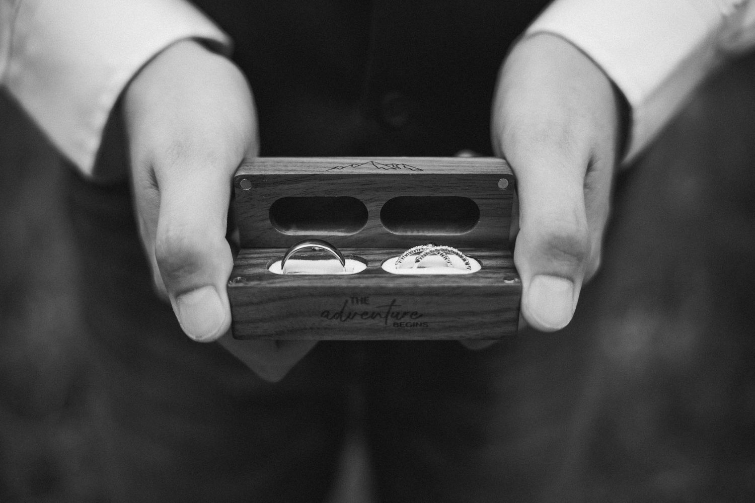 Black and white close-up shots of hands holding a ring box.