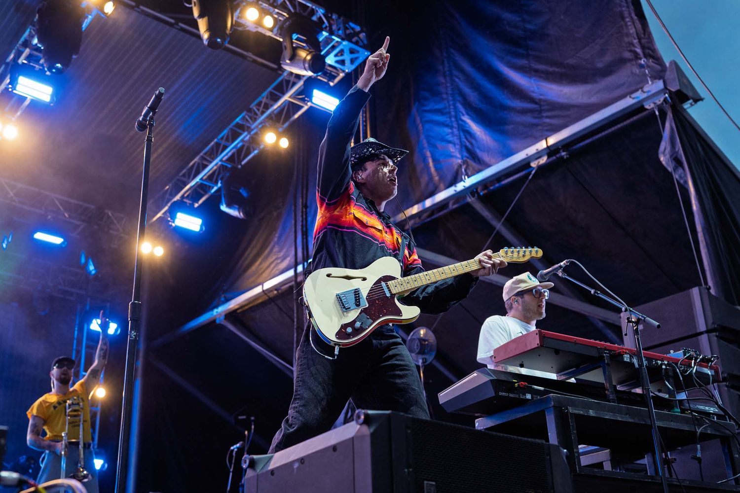 The Arkells performing on stage with dramatic blue stage lighting and equipment.