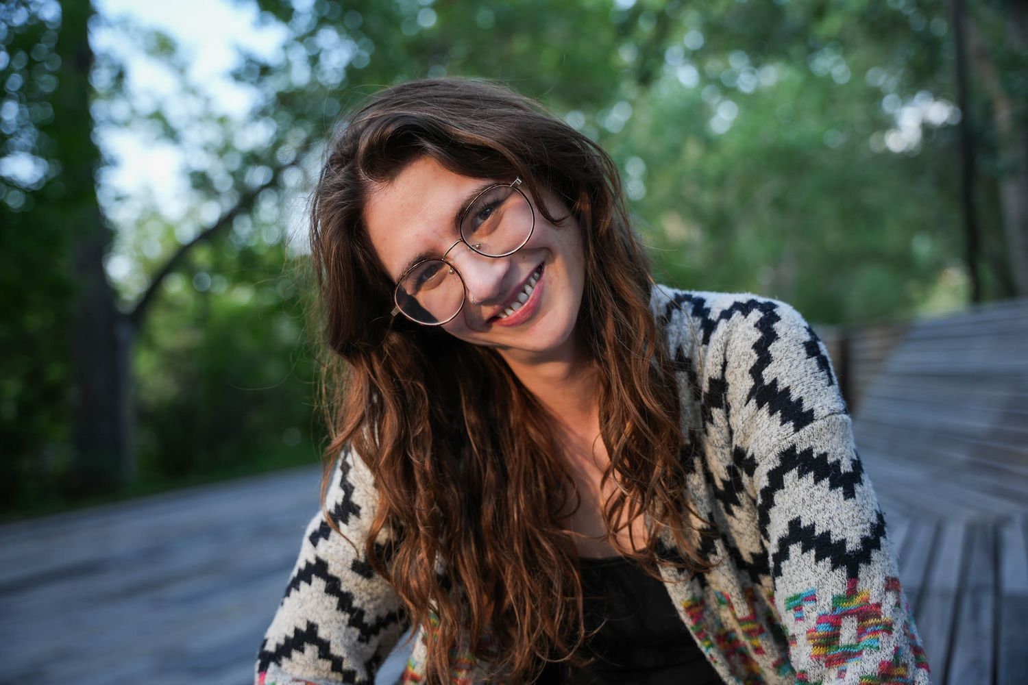 Casual outdoor portrait session featuring patterned sweater and natural scenery.