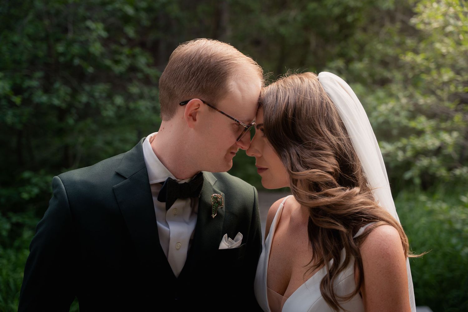 Romantic forest wedding portraits captured in soft natural lighting.